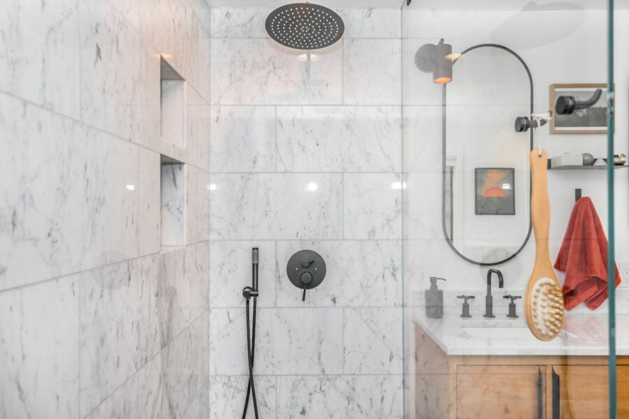 Overhead shower head and handheld shower in a tiled bathroom