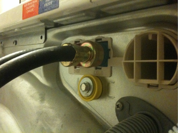 A fill hose coupling attached to the rear inlet of a Frigidaire washing machine.